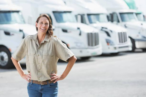 White trucks fleet behind an employee of a logistics company in Calgary, Canada